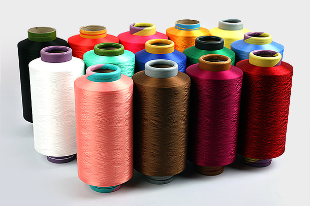 Quali sono i principali vantaggi derivanti dall'utilizzo dei filati di poliestere DTY nelle applicazioni tessili e in che modo il loro processo di produzione contribuisce alla loro popolarità e all'uso diffuso nell'industria tessile?