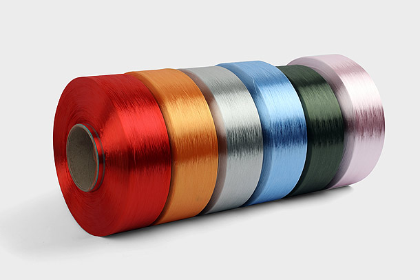 Il filato di poliestere tinto in massa è un tipo di fibra tessile prodotta dalla polimerizzazione chimica dell'etilene e di un colorante